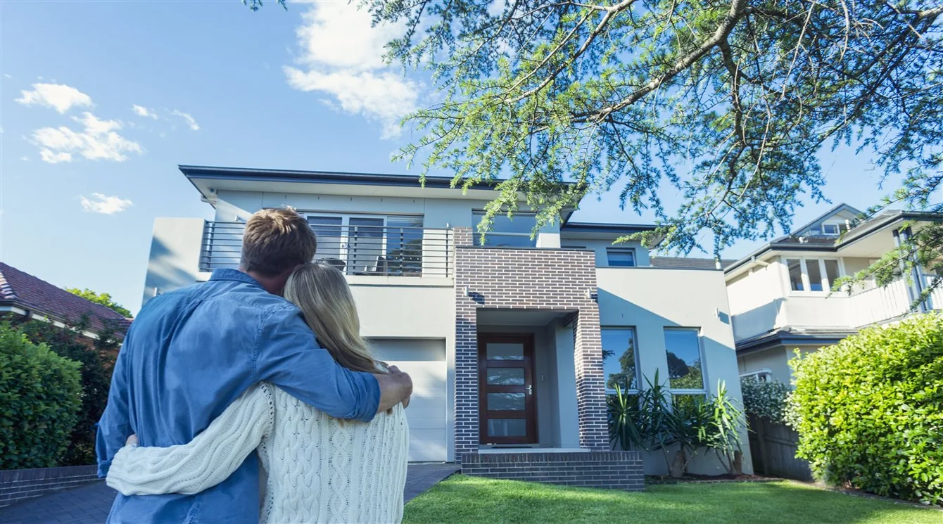 A couple looking toward their home